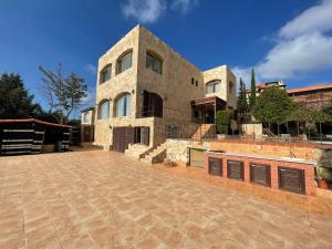 a large stone house with a large patio at Horizon 3 Villa in Amman
