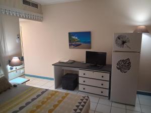 a bedroom with a desk with a television and a bed at Charmant Studio CRISTAL COCO Les Trois-Îlets Martinique in Les Trois-Îlets +17 photos