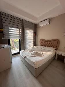 a bedroom with a large bed and a large window at Lotus 4 Mevsim Otel in Ayvalık