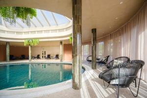 a swimming pool in a hotel with chairs and a building at Terceira Mar Hotel in Angra do Heroísmo