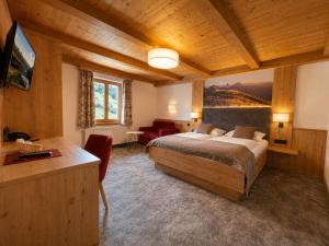 a bedroom with a bed and a desk in a room at Hotel Bechlwirt in Kirchberg in Tirol