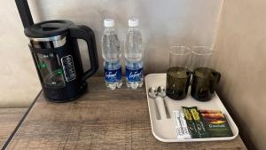 a tray with bottles of water and glasses on a counter at Кристалл in Bosteri