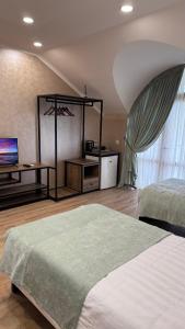 a bedroom with two beds and a television in a room at Кристалл in Bosteri