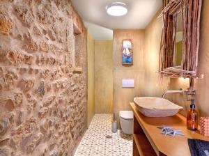a bathroom with a sink and a stone wall at Melias Olive Retreat in Kelefá +93 photos