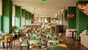 a restaurant with green walls and tables and chairs at Sao Miguel Park Hotel in Ponta Delgada