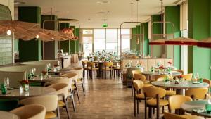 a restaurant with green walls and tables and chairs at Sao Miguel Park Hotel in Ponta Delgada