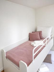a white bed with a white frame and pink pillows at Apartament Premium Orzysz in Orzysz