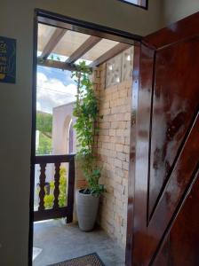 a door leading to a porch with a potted plant at Chale Selah Gameleiras in Monte das Gameleiras