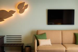 a living room with a couch and a tv at Sao Miguel Park Hotel in Ponta Delgada +10 photos