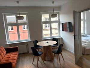 a living room with a table and chairs and a couch at Amulet Poznan Old Town in Poznań +5 photos