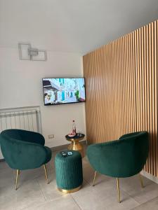 two green chairs and a table in a room at Caterina City House in Monopoli