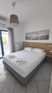 a bedroom with a large white bed with white pillows at Villa Rodanthi Sivota in Syvota