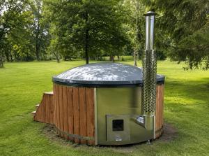 a hot tub with a shower in the grass at Nesta's Nook in Llandovery