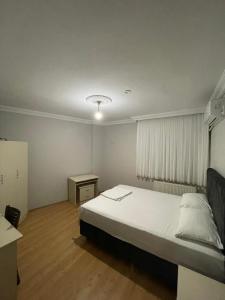 a bedroom with a bed and a table and a window at PELİTLİ REZİDANS Otel in Trabzon