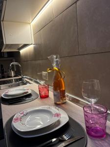 a kitchen counter with plates and wine glasses and a sink at Caterina City House in Monopoli