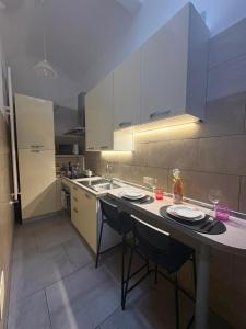 a kitchen with white cabinets and a table with chairs at Caterina City House in Monopoli