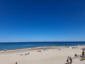 a group of people on a beach near the ocean at Pensjonat nad Stawem in Sarbinowo +11 photos