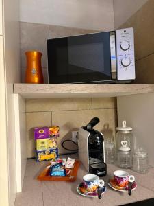 a microwave on a shelf with two cups and a printer at Caterina City House in Monopoli +5 photos