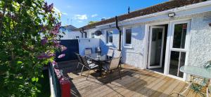 a patio with a table and chairs on a wooden deck at Cosy Bungalow in Balbriggan
