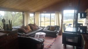 a living room with couches and a table and windows at Luna Llena in Suesca