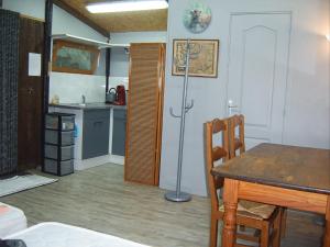 a dining room with a table and a kitchen at Chalet de campagne LAJA only 5 min from autoroute A75 in Léotoing
