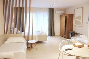 a hotel room with a bed and a table and a room at Thassos Studio Kai Lani in Potamiá