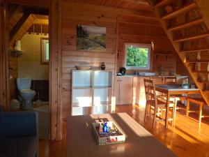 eine Küche mit Kühlschrank und Tisch in einem Zimmer in der Unterkunft Domki WiliCamp in Polańczyk