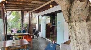 a room with tables and chairs and a stone wall at Hotel Sumpa in Montañita