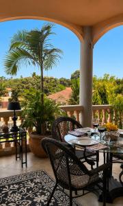 a patio with a table and chairs and a palm tree at RoofTop Boutique Hotel Adults Only in Serekunda