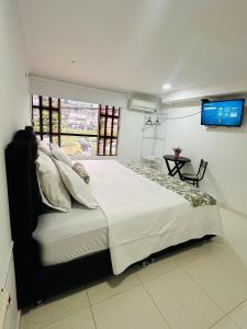 ein Schlafzimmer mit einem großen Bett und einem Fernseher an der Wand in der Unterkunft Hotel plata inn in Villavicencio + 14 Fotos