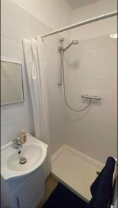 a white bathroom with a sink and a shower at Catherine Lodge Finchley in Whetstone