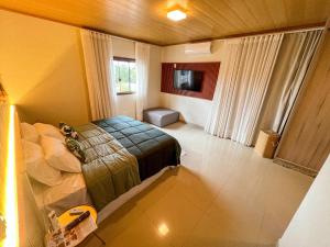 a bedroom with a bed and a television in it at Jungla House Hostel in Alto Paraíso de Goiás