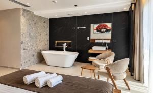 a bathroom with a bath tub and a sink at Hotel & Restaurant HAREA in Suharekë
