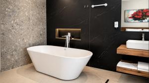 a bathroom with a white tub and a sink at Hotel & Restaurant HAREA in Suharekë