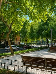 a park with two benches and a fence at Centrico apartamento en Leganes in Leganés