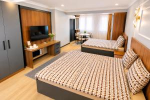 a hotel room with two beds and a television at Asil house in Istanbul