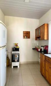 a kitchen with a white stove and a refrigerator at Casa em Itaúnas para temporada e carnaval in Itaúnas