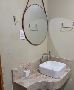 a bathroom with a sink and a mirror at Casa em Itaúnas para temporada e carnaval in Itaúnas +14 photos