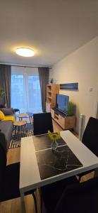 a living room with a couch and a table at Apartament Grey 2 pokojowy z balkonem w Warszawie z parkingiem podziemnym in Warsaw