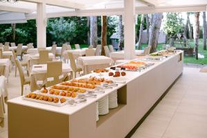 a buffet line with food on plates and tables at Hotel Gallia & Resort in Lido di Jesolo