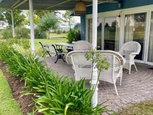 a patio with wicker chairs and a table on a porch at Petion Polo Ranch in Cañuelas