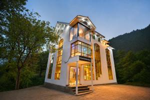a large white house with a lot of windows at Forest Grandeur Resort in Anantnāg