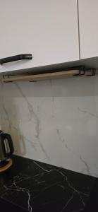 a white wall with a counter top and a shelf at Apartament Grey 2 pokojowy z balkonem w Warszawie z parkingiem podziemnym in Warsaw +47 photos