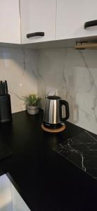 a tea kettle on a counter in a kitchen at Apartament Grey 2 pokojowy z balkonem w Warszawie z parkingiem podziemnym in Warsaw