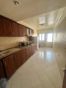 a large kitchen with wooden cabinets and a large window at Perfect stay in Agadir