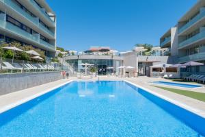 a swimming pool in front of a building at Apolo Suites Rentalmar in Salou