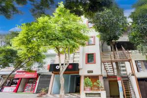a tree in front of a white building at Hotel O Royal Inn Hotel in Dīgha +24 photos