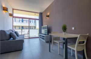 a living room with a couch and a table and a tv at Apolo Suites Rentalmar in Salou