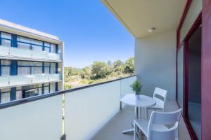a balcony with a table and chairs and a building at Apolo Suites Rentalmar in Salou