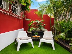 two chairs and a table in a courtyard with plants at Deluxe Coliving Islas Canarias in Las Palmas de Gran Canaria